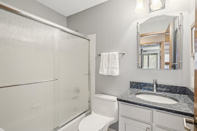 full bathroom featuring vanity, a textured ceiling, combined bath / shower with glass door, and toilet