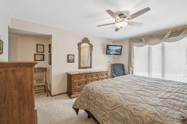 carpeted bedroom with ceiling fan and a textured ceiling