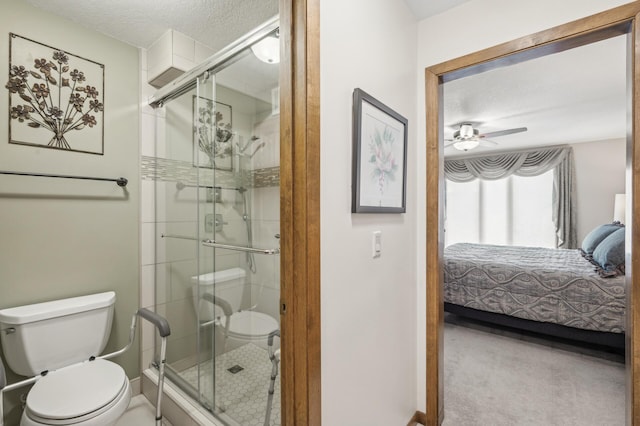 bathroom with ceiling fan, toilet, an enclosed shower, and a textured ceiling