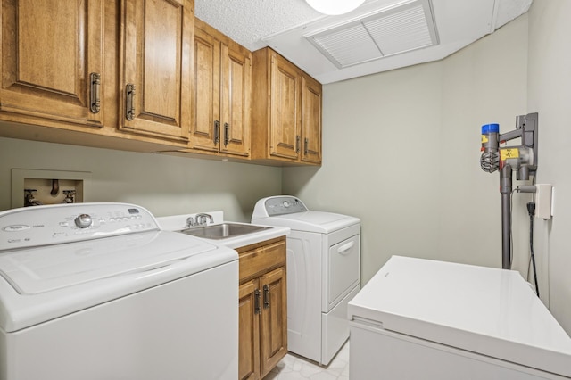 laundry area with cabinets, sink, and washer and clothes dryer