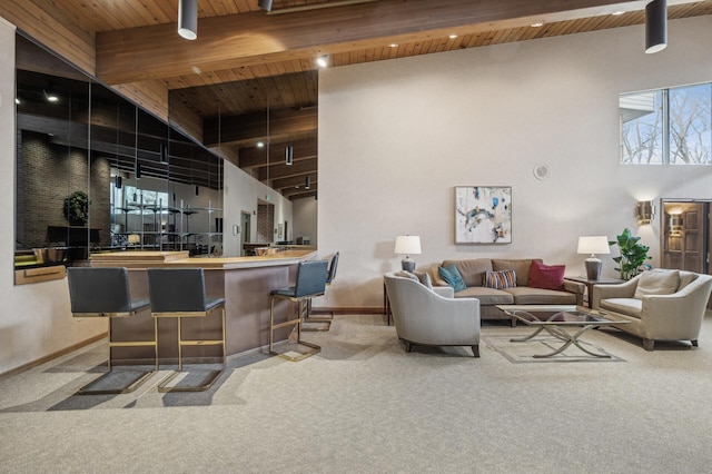 bar with a towering ceiling, plenty of natural light, wooden ceiling, and carpet