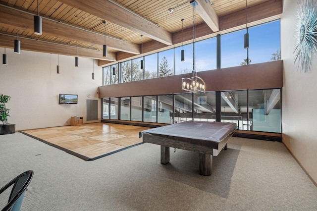 game room featuring wood ceiling, plenty of natural light, beamed ceiling, and carpet flooring