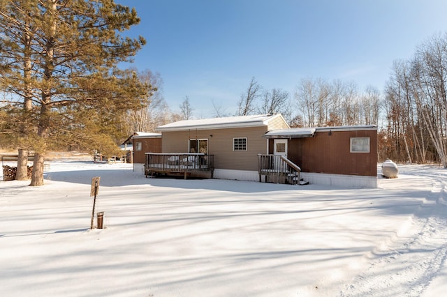 snow covered rear of property featuring a deck