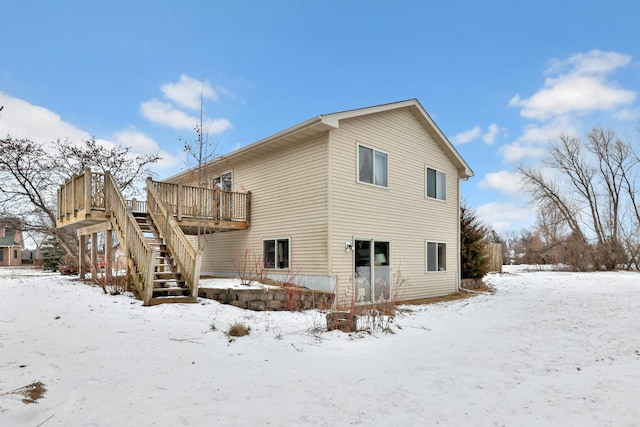 snow covered house featuring a deck