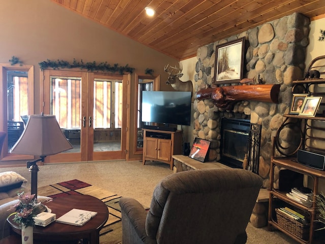 carpeted living room with a stone fireplace, vaulted ceiling, wooden ceiling, and french doors