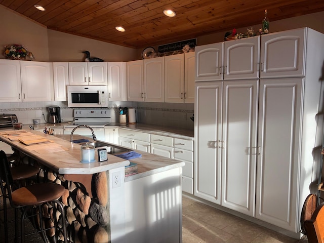 kitchen with white cabinets, a kitchen breakfast bar, decorative backsplash, wood ceiling, and white appliances