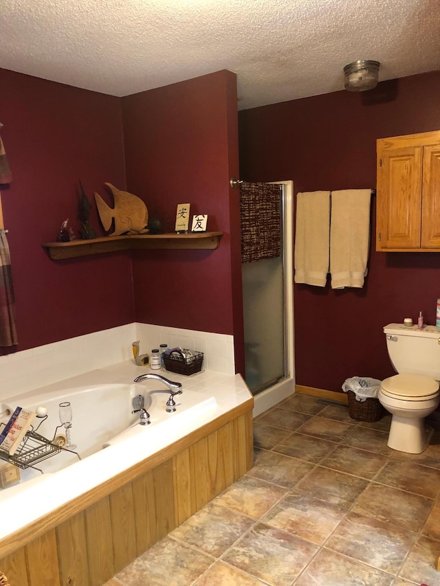 bathroom featuring toilet, plus walk in shower, and a textured ceiling