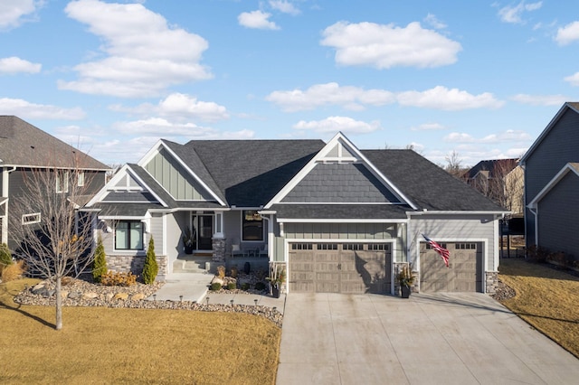 craftsman-style house featuring board and batten siding, stone siding, a garage, concrete driveway, and a front yard