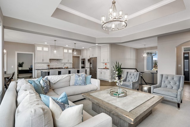 living room with a chandelier, recessed lighting, wood finished floors, arched walkways, and baseboards