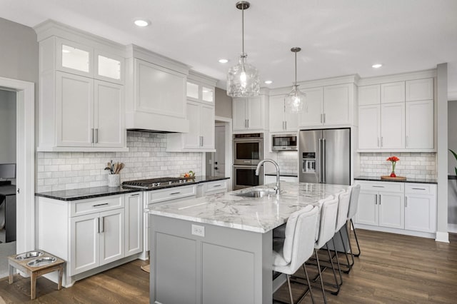 kitchen with stainless steel appliances, a sink, white cabinetry, backsplash, and recessed lighting