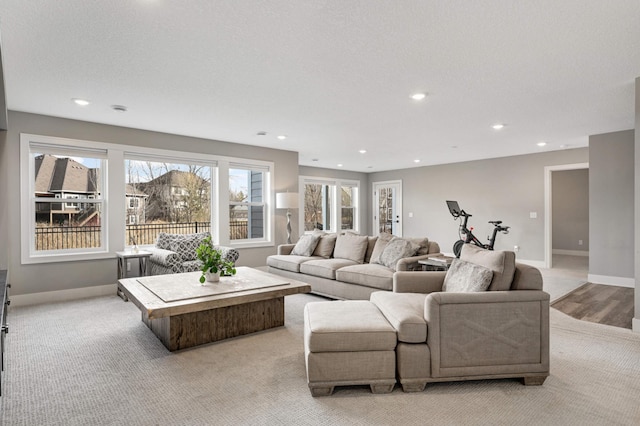 living area with recessed lighting, baseboards, and light colored carpet