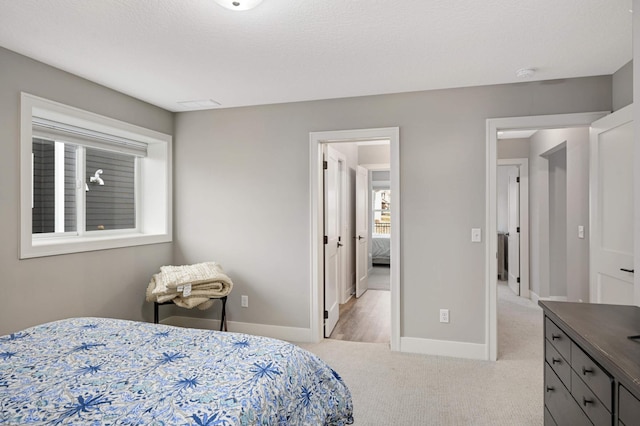 bedroom with light carpet and baseboards