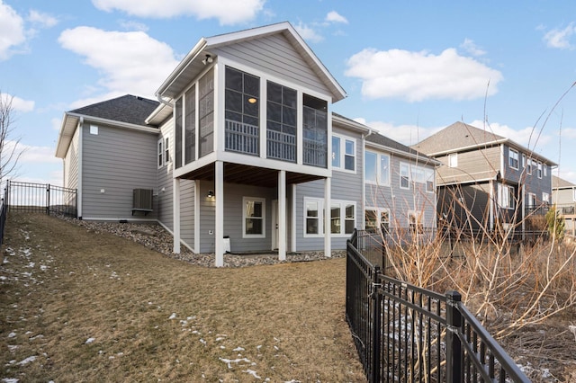 back of property with cooling unit, a sunroom, and fence