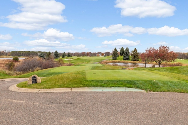 view of property's community featuring golf course view, a water view, and a yard