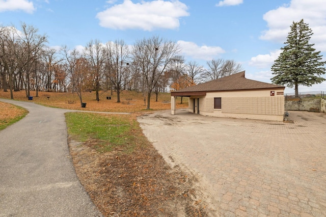 view of front of house with driveway, roof with shingles, and fence