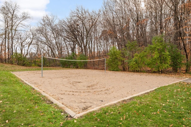 surrounding community with volleyball court and a lawn