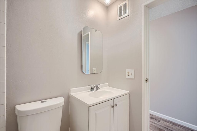 bathroom featuring vanity, toilet, and wood-type flooring