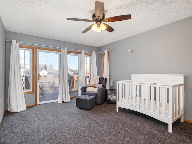 bedroom with ceiling fan, access to outside, a textured ceiling, and dark colored carpet