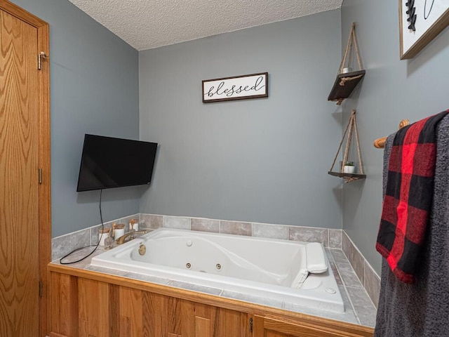 bathroom featuring tiled bath and a textured ceiling