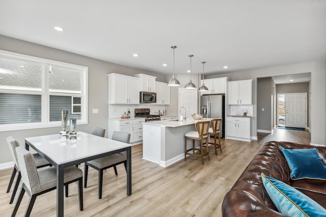 dining room featuring sink and light hardwood / wood-style flooring