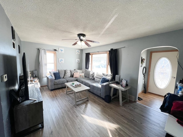 living room with ceiling fan, a healthy amount of sunlight, hardwood / wood-style floors, and a textured ceiling