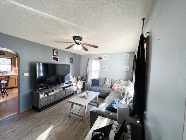 living room featuring hardwood / wood-style floors, a textured ceiling, and ceiling fan