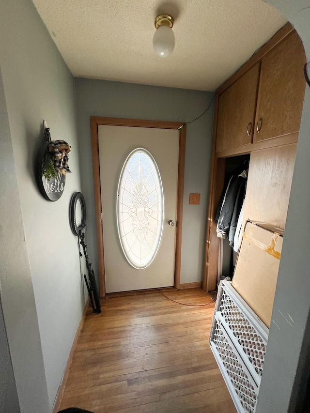 entryway featuring light hardwood / wood-style flooring and a textured ceiling