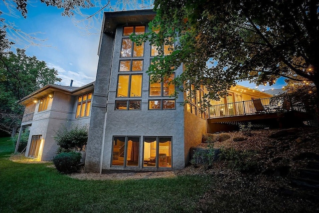 back of house featuring a deck and a lawn