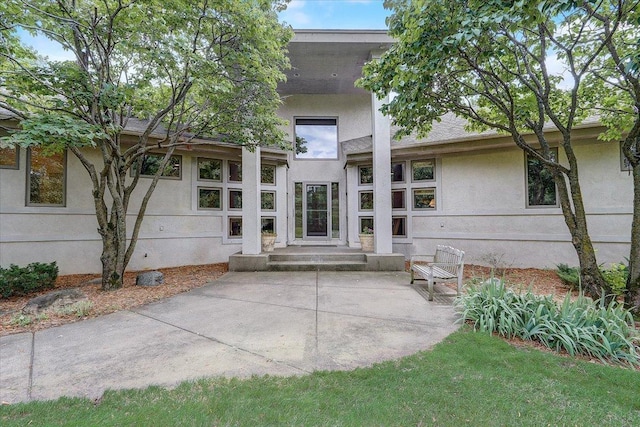 view of exterior entry with a patio area