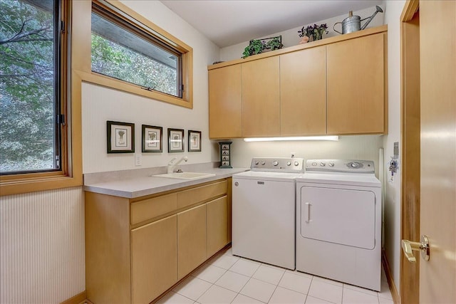 clothes washing area with sink, light tile patterned floors, cabinets, and independent washer and dryer