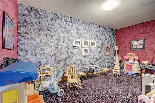 game room with a textured ceiling and carpet flooring