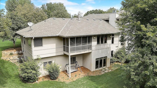 back of house featuring a sunroom, a yard, and central AC