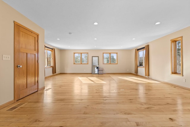 unfurnished living room with a healthy amount of sunlight and light hardwood / wood-style floors