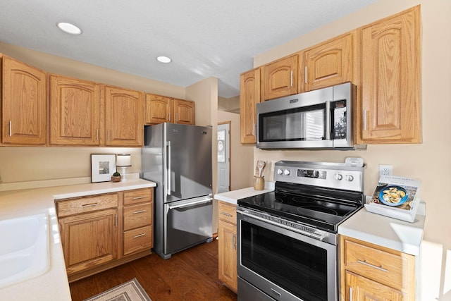 kitchen featuring stainless steel appliances, sink, light brown cabinets, and dark hardwood / wood-style floors