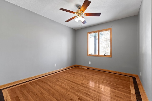 empty room with hardwood / wood-style floors, a textured ceiling, and ceiling fan