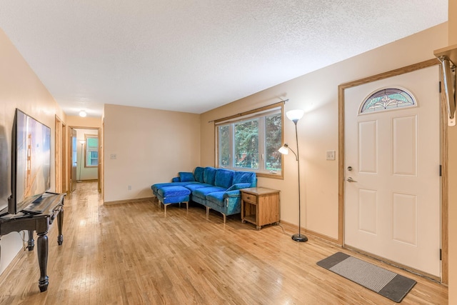 entrance foyer with light hardwood / wood-style flooring and a textured ceiling