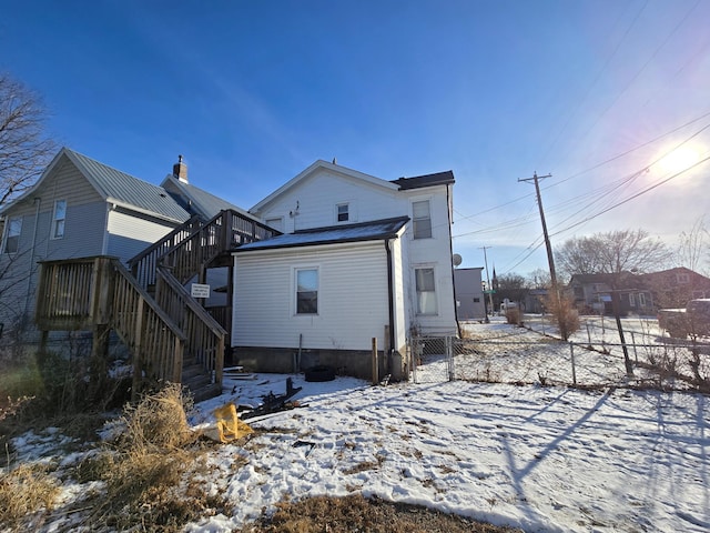 view of snow covered back of property