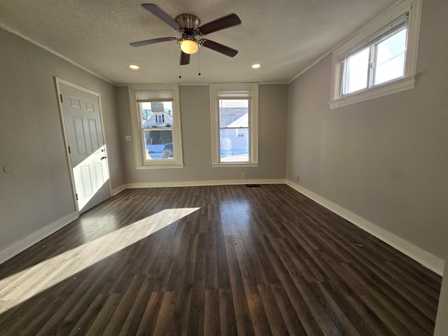 empty room featuring ornamental molding, dark hardwood / wood-style floors, and a textured ceiling