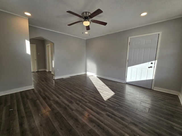 empty room with ceiling fan, ornamental molding, and dark hardwood / wood-style flooring