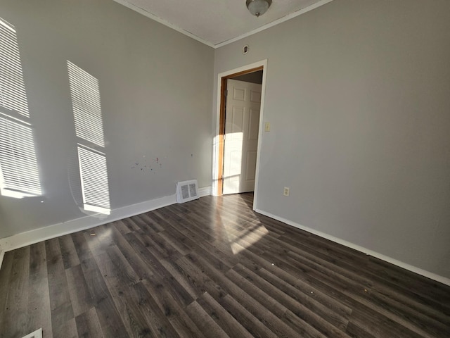 unfurnished room featuring dark wood-type flooring and ornamental molding