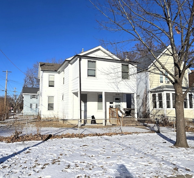 snow covered rear of property with covered porch