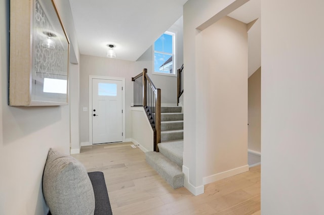 entrance foyer with stairway, wood finished floors, and baseboards