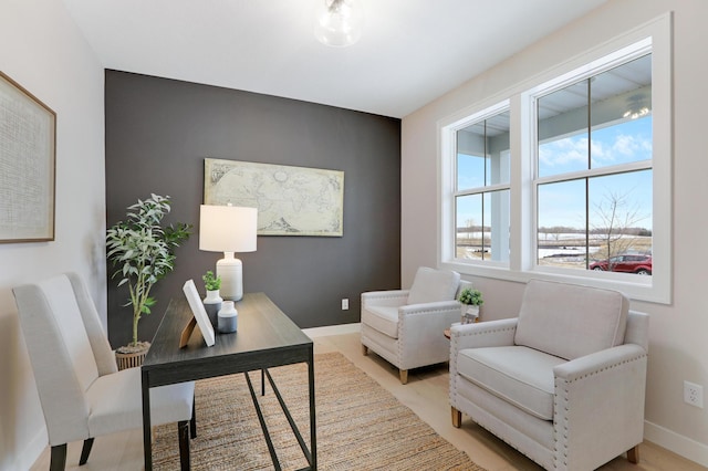 office space with baseboards and light wood finished floors