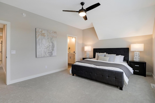 carpeted bedroom featuring baseboards, vaulted ceiling, ensuite bathroom, and ceiling fan
