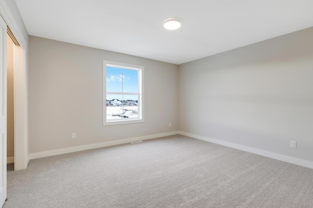 unfurnished bedroom with light colored carpet, baseboards, and a closet