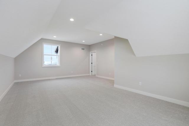 additional living space with lofted ceiling, light colored carpet, baseboards, and recessed lighting