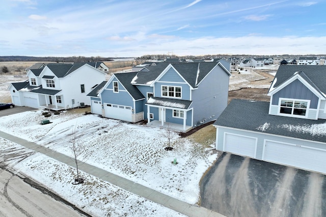 snowy aerial view featuring a residential view