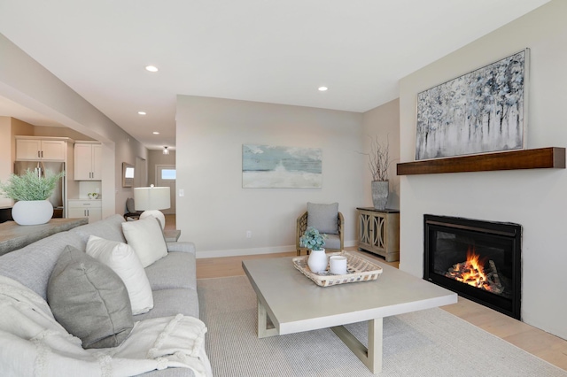 9568 63rd St S, Cottage Grove, MN 55016 - living room with light wood-style floors, recessed lighting, a glass covered fireplace, and baseboards