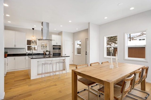 dining space featuring plenty of natural light, sink, and light wood-type flooring