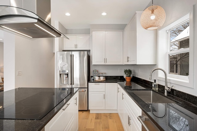 kitchen featuring decorative light fixtures, island range hood, white cabinets, and dark stone counters